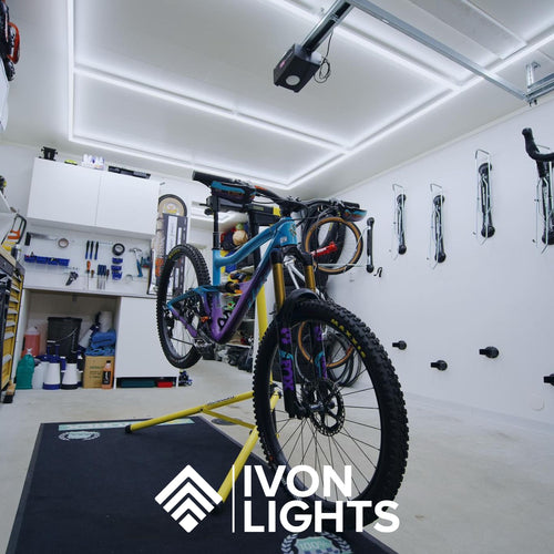 Bild på IVON Full Size Rectangle Kit Belysning monterad i taket med en cykel som motiv, vilket ger ett modernt garageintryck.